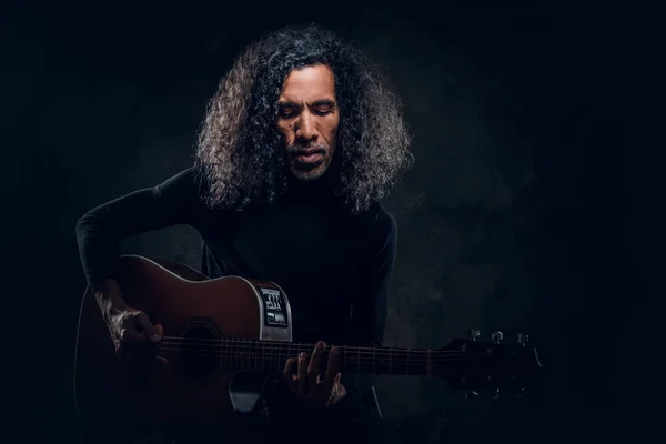 Homem está tocando guitarra enquanto posando para fotógrafo — Fotografia de Stock