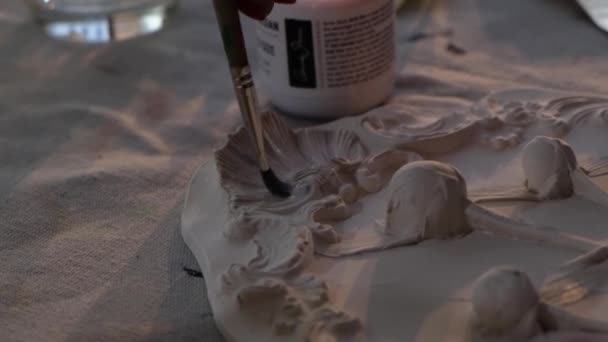 Κοντινό πλάνο βίντεο της διακόσμησης λευκό πιάτο. Κάμερα αργά ολίσθηση από τη μετακίνηση βούρτσα στο χέρι των καλλιτεχνών. — Αρχείο Βίντεο