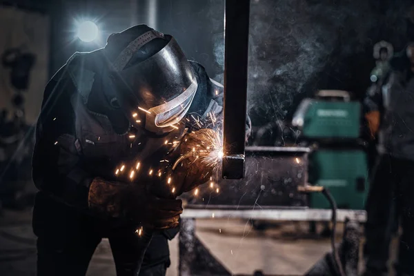 Człowiek pracuje w ruchliwej fabryce metalu. — Zdjęcie stockowe