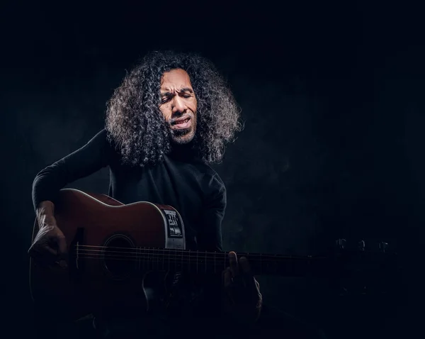 Homem está tocando guitarra enquanto posando para fotógrafo — Fotografia de Stock