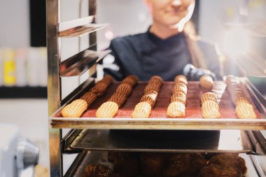 Kadın pastanede pastacıda çalışıyor.