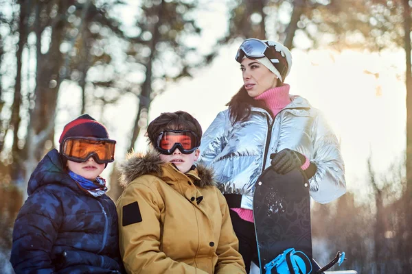 겨울 숲에 스노보드를 타고 있는 우호적 인 가족 — 스톡 사진