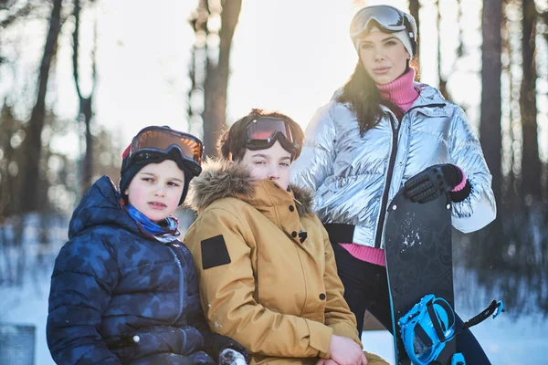 Vänlig familj med snowboard på vintern skog — Stockfoto