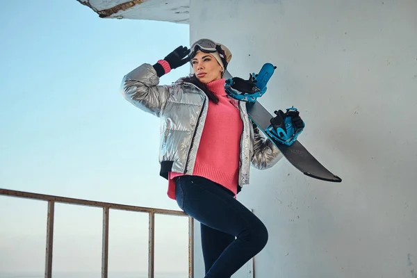 Очаровательная леди со сноубордом позирует фотографу — стоковое фото