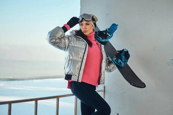 Senhora encantadora com snowboard está posando para fotógrafo — Fotografia de Stock