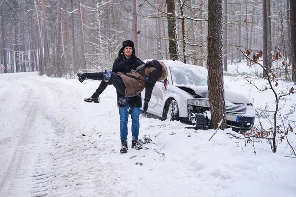 L'homme tient une femme blessée après un accident de voiture — Photo