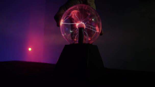 La mano toca la lámpara de plasma en el cuarto oscuro — Vídeos de Stock