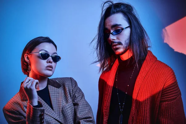 Un par de hipsters bajo luces rojas y azules — Foto de Stock