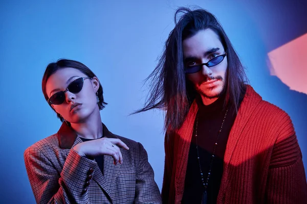 Un par de hipsters bajo luces rojas y azules — Foto de Stock