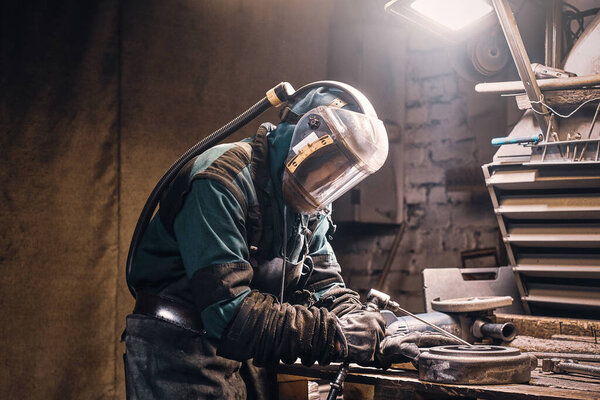 Busy man is working on metal factory