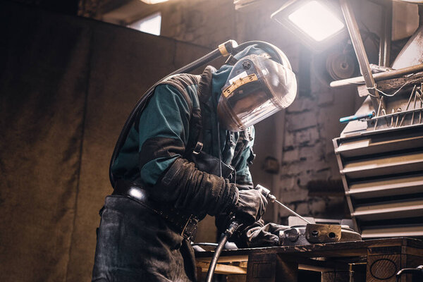 Busy man is working on metal factory
