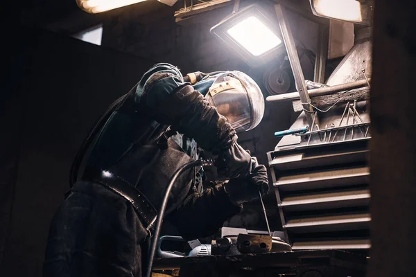 Pečlivý muž pracuje s kovem v dílně — Stock fotografie