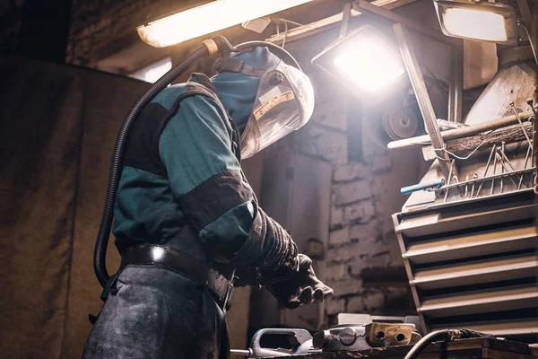 Pečlivý muž pracuje s kovem v dílně — Stock fotografie