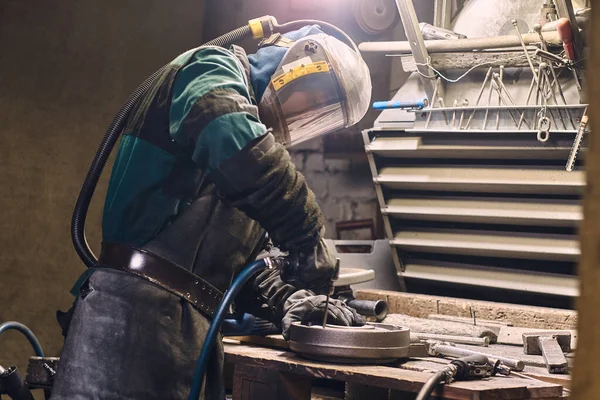 Homem diligente está trabalhando com metal na oficina — Fotografia de Stock