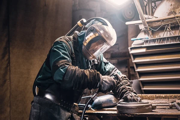 Homem diligente está trabalhando com metal na oficina — Fotografia de Stock