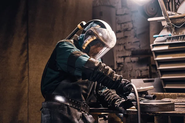 Pečlivý muž pracuje s kovem v dílně — Stock fotografie