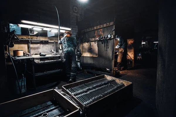 De ijverige mens werkt met metaal in de werkplaats — Stockfoto