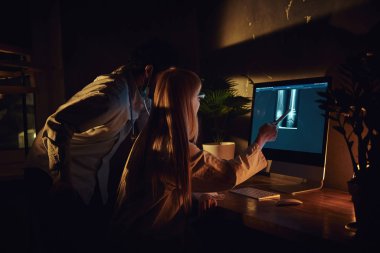 İki doktor karanlık ofiste çalışıyor.