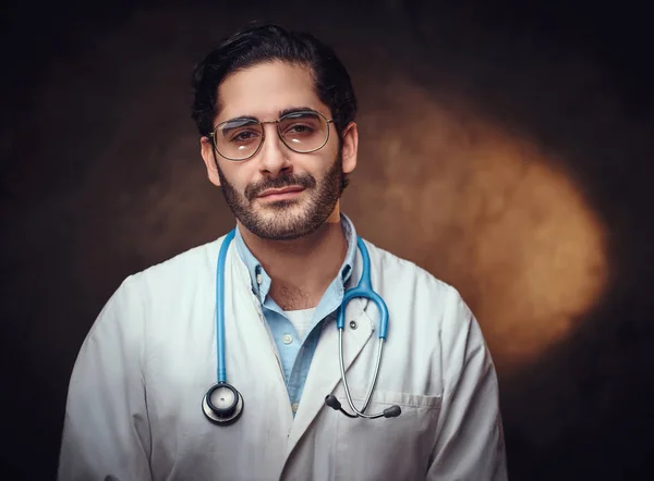 Portré okos jóképű orvos felett sötét háttér. — Stock Fotó