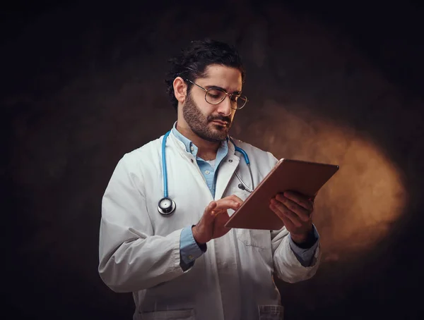 Retrato del médico enfocado con el comprimido en las manos —  Fotos de Stock