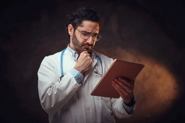 Retrato de médico focado com tablet nas mãos — Fotografia de Stock