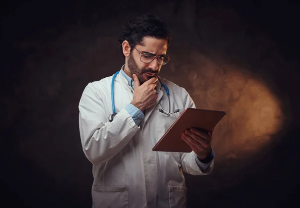 Портрет сфокусированного врача с таблеткой в руках — стоковое фото