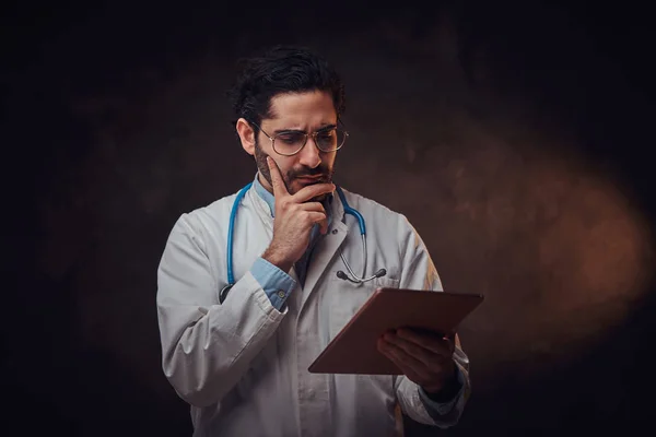 Retrato del médico enfocado con el comprimido en las manos —  Fotos de Stock