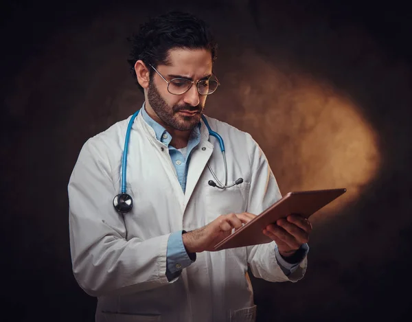 Retrato del médico enfocado con el comprimido en las manos —  Fotos de Stock