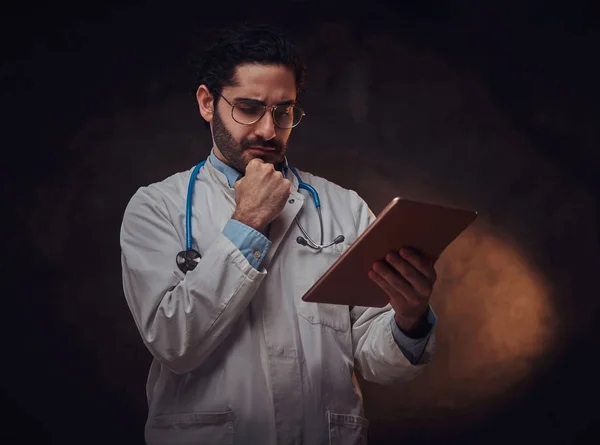 Retrato del médico enfocado con el comprimido en las manos —  Fotos de Stock