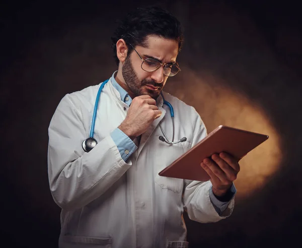 Retrato del médico enfocado con el comprimido en las manos —  Fotos de Stock