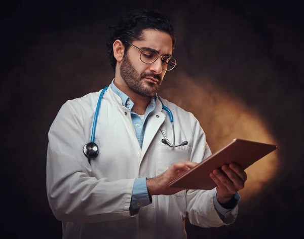 Portrait de médecin concentré avec comprimé dans les mains — Photo