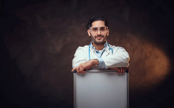 Handsome medic with white board in hands