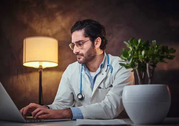 Jeune médecin en lunettes à son bureau — Photo