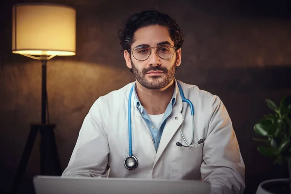 Fiatal orvos szemüvegben az irodájában. — Stock Fotó