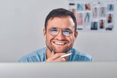 Elinde kalemle gözlüklü bir adam portresi.