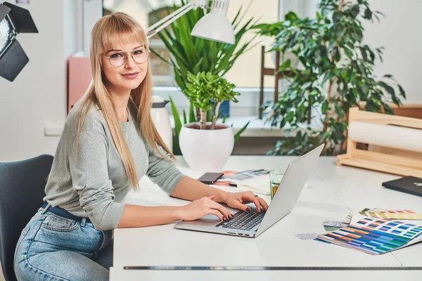 Jolie femme est assise dans le bureau — Photo