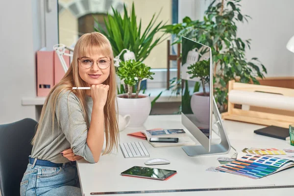 Jolie femme est assise dans le bureau — Photo