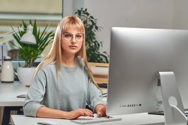 Νεαρή γυναίκα δουλεύει με υπολογιστή. — Φωτογραφία Αρχείου