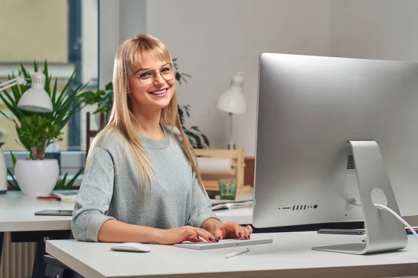 若い女性がコンピューターを使って働いています — ストック写真