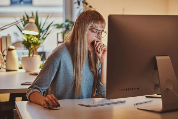 Mulher se sente cansada enquanto trabalha no escritório — Fotografia de Stock