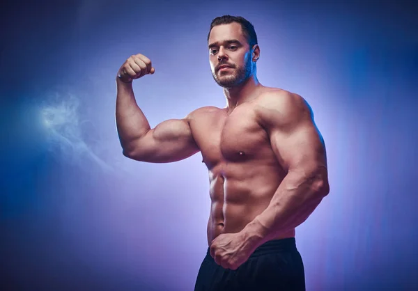 Портрет красивого мускулистого мужчины в фотостудии — стоковое фото