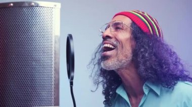 Afrikalı adam stüdyoda şarkı söylüyor.