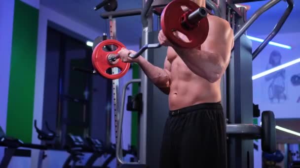Muscular hombre tiene un entrenamiento en el gimnasio — Vídeos de Stock