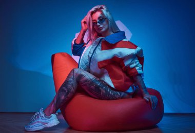 Sarışın kadın fasulye çuvalında oturuyor.