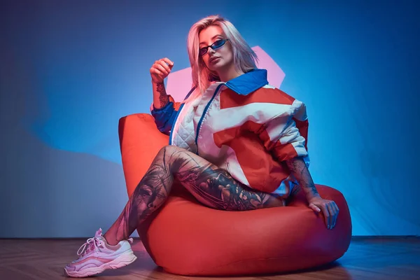 Blond woman is sitting on bean bag — 스톡 사진