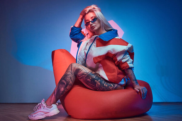 Blond woman is sitting on bean bag