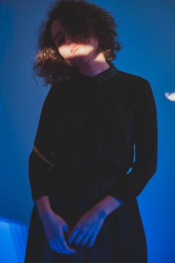 Yüzünde ışık çizgisi olan kıvırcık kadın.