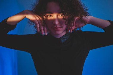 Yüzünde ışık çizgisi olan kıvırcık kadın.