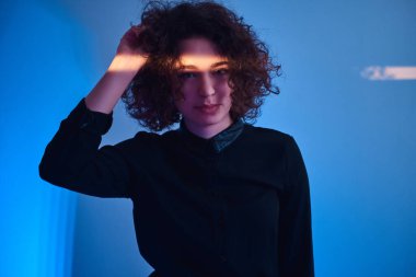 Yüzünde ışık çizgisi olan kıvırcık kadın.