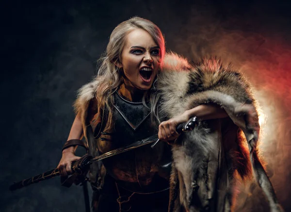 Fantasy kobieta rycerz noszący cuirass i futro, trzymając miecz i pędzi do walki z wściekłym płaczem. Cosplayer jako Ciri z Wiedźm. — Zdjęcie stockowe